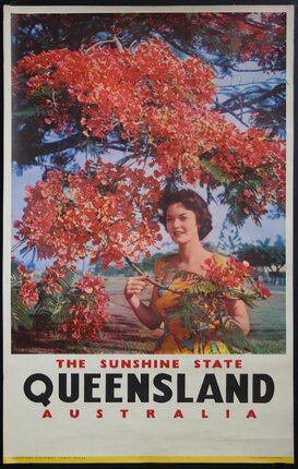 a woman holding a tree with red flowers