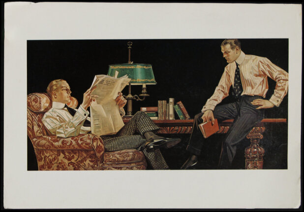 a man reading a newspaper while another man sits on a couch