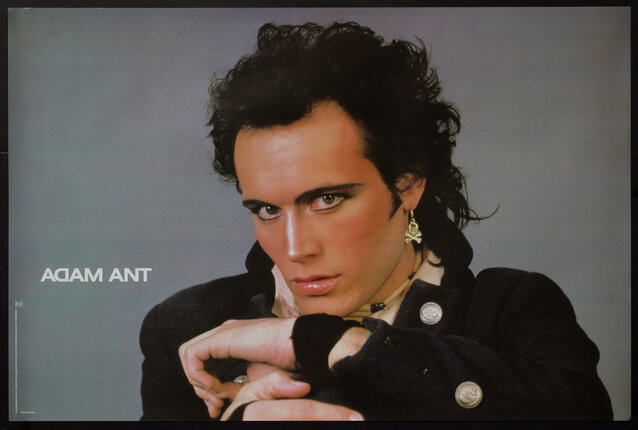 A poster of a man (Adam Ant) wearing dramatic eyeliner and a skull and crossbones earring posing with his chin on his hands