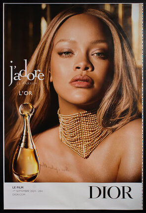 poster with a young woman (Rihanna) with a large pearl choker necklace and a perfume bottle